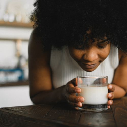 African american women smelling a scented soy candle.